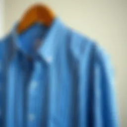 Elegant blue striped shirt hanging on a classic wooden hanger