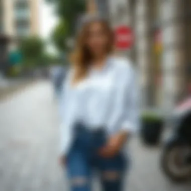 Woman wearing an oversized white shirt paired with jeans in a trendy urban setting.